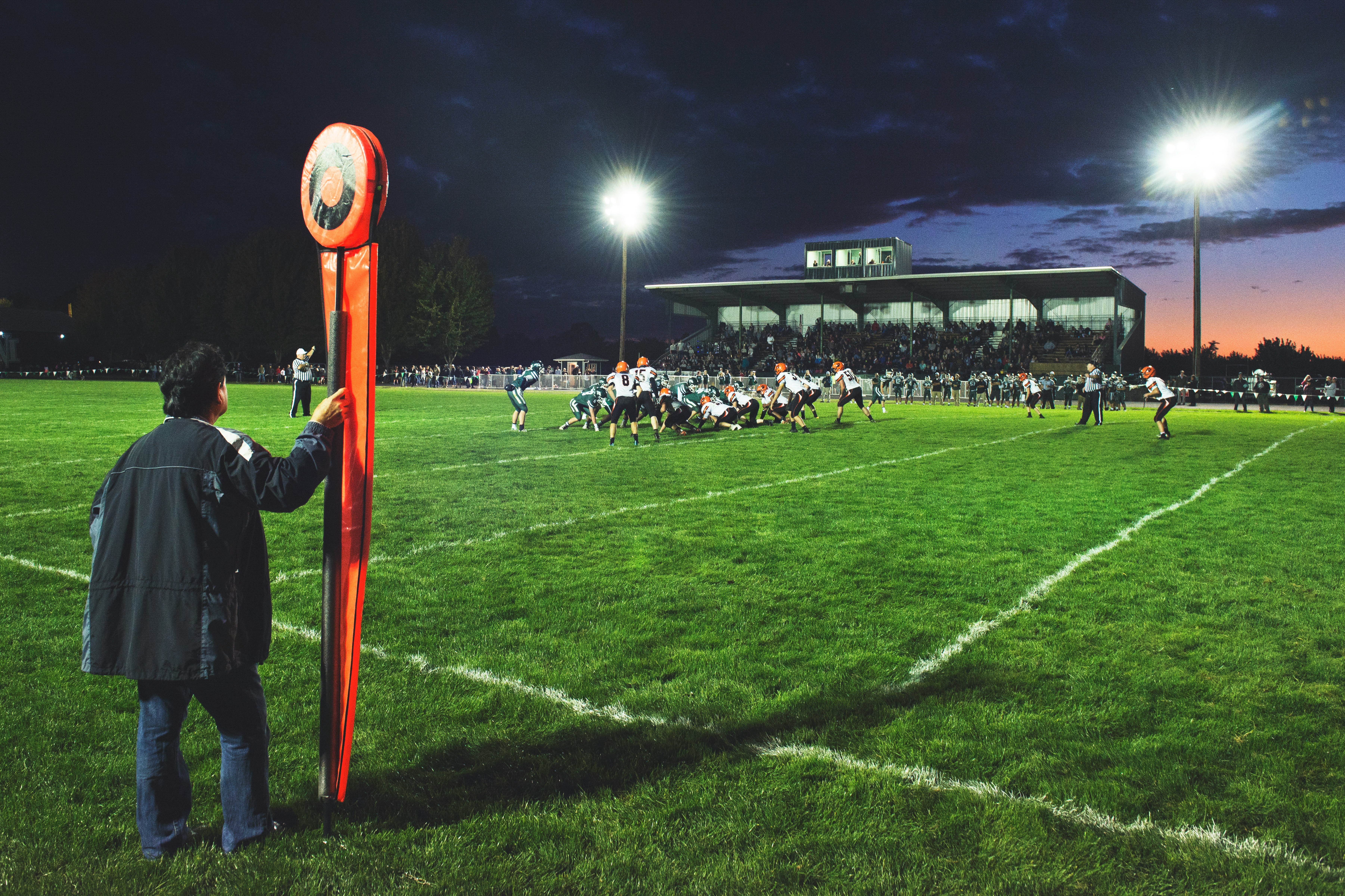 man holding football field post on side of field